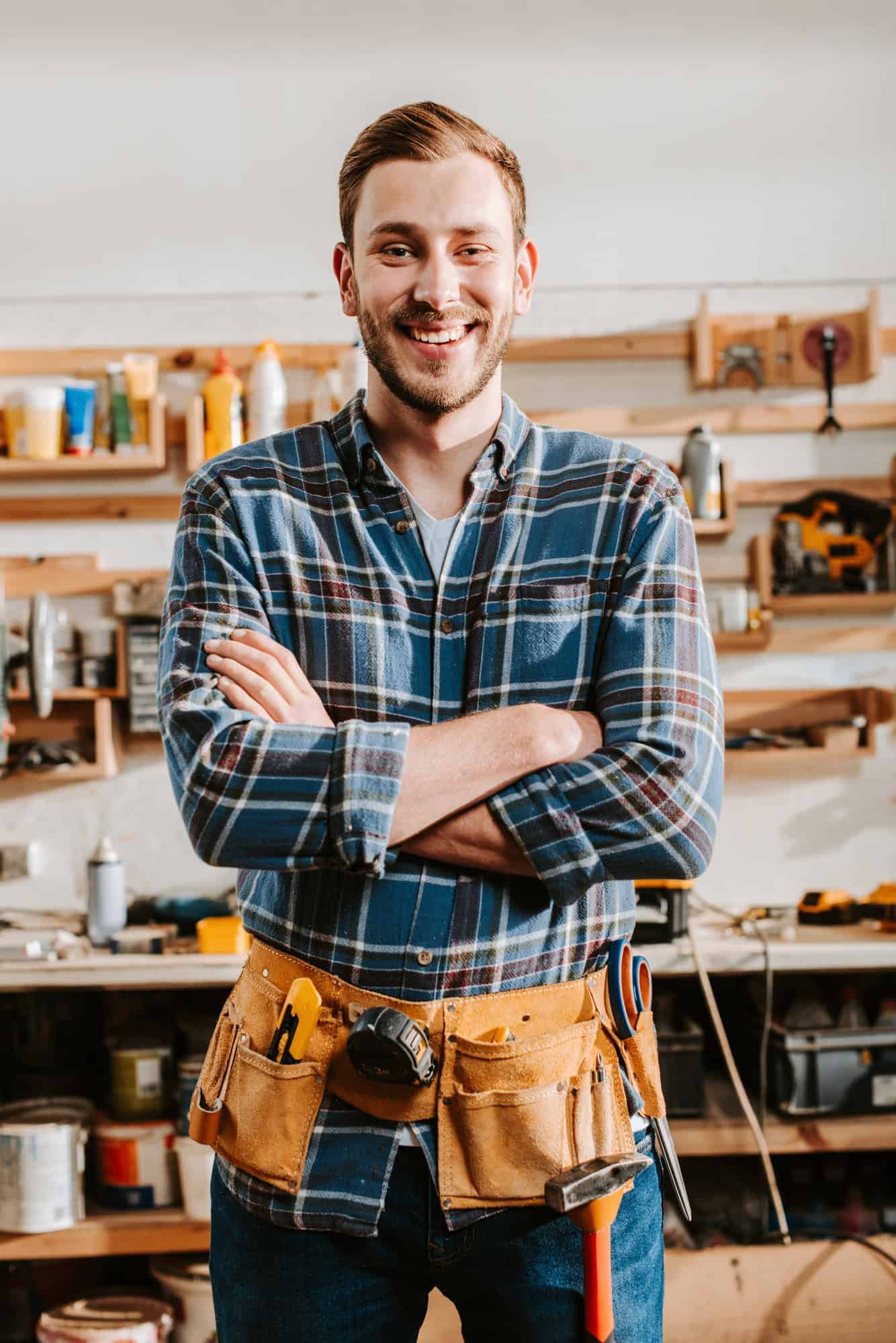 happy carpenter in apron standing with crossed arms jpg